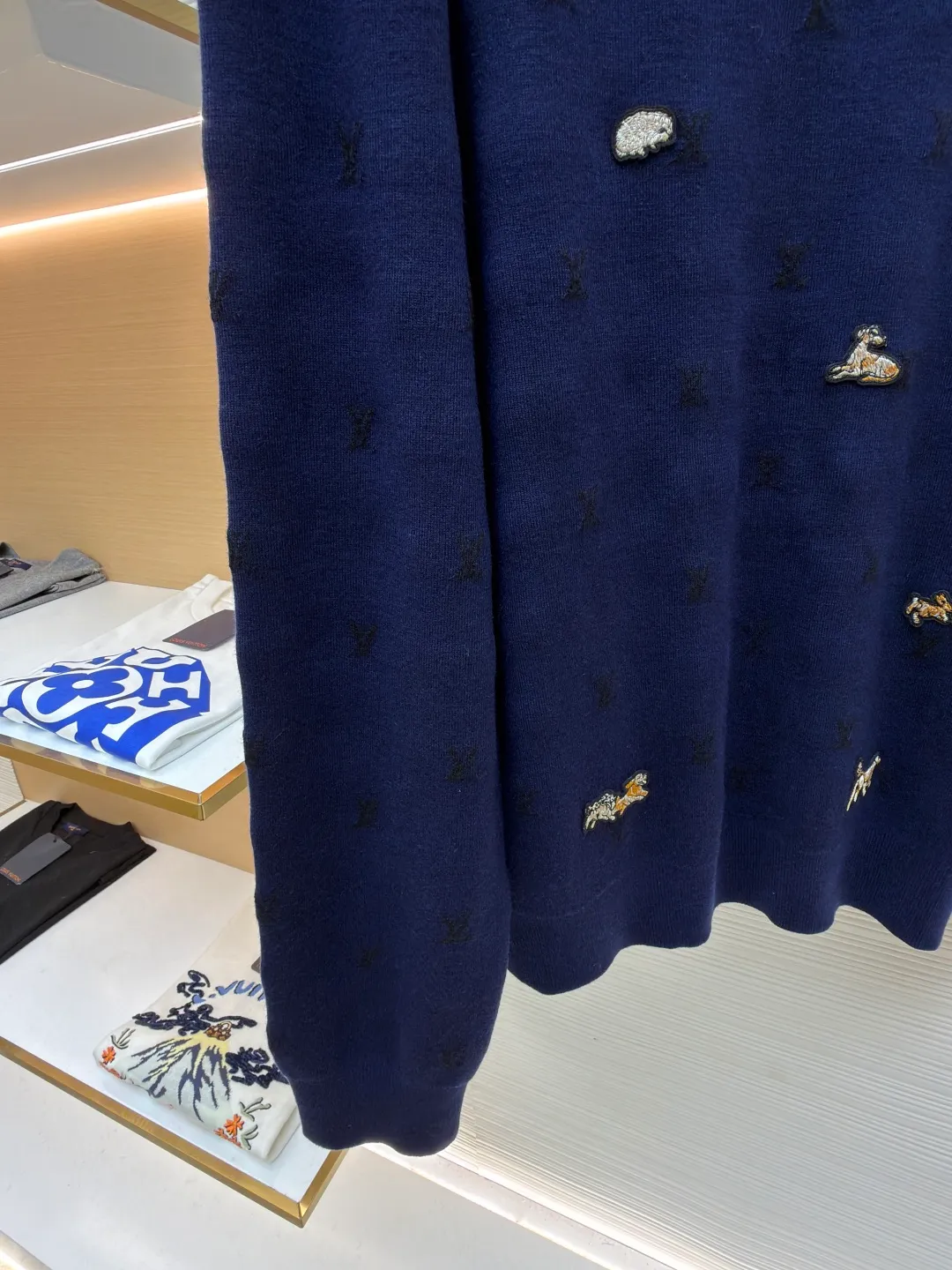LOUIS VUITTON animal embroidered wool crew neck sweater ●Original version: purchased and developed by 18025 ●Item number: 1682089-B05 ●Fabric: wool blended fabric ●Technology: knitted embroidery production ●Color: navy blue ●Version: fitted version ●Weight: about 590 grams ●Size: XS-S-M-L ●Description: This Louis Vuitton navy blue sweater is made of ultra-fine merino wool blended yarn and is knitted by worsted knitting technology. It uses 16-needle high-density plain knitting technology to give the fabric a silky delicate touch and matte texture. The base of the body is also woven with a mini Monogram pattern using a same-color dark jacquard technology. The pattern is low-key and naturally blends with the wool texture. The decorative details embellished on the body are made of hand-made beading and metal veneer inlays. The veneer is aged by electroplating and enamel color-filled. Every decoration is hand-positioned and sewn by craftsmen to ensure firmness and a beautiful arrangement. The round neckline adopts double-needle overlock knitting technology, which is not easy to deform and fits the neck. The side seams and hem of the body use seamless splicing technology to reduce friction when wearing. The overall stitching is even and fine, fully demonstrating the brand's exquisite craftsmanship and detail control in the field of knitted garments. The overall wiring is straight and delicate, the fabric is comfortable and soft, and the color is consistent without color difference. It can be matched with the same style to create a fashionable look and control various occasions. Customized accessories, complete with three standards, same style for men and women!